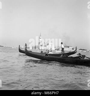 Anni Venti anni trenta due gondole in Laguna Venezia Italia - r7259 HAR001 HARS Mediterraneo Gondola barca a remi ADRIATICO MARE ADRIATICO B&W IN BIANCO E NERO RACCHIUSO BAY con fondo piatto gondole gondoliere faticando laguna occupazioni vecchio fiume Piave FIUME PO TRASPORTI PUBBLICI LAGUNA DI VENEZIA VENETO Foto Stock