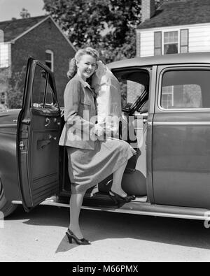 Negli anni quaranta anni cinquanta sorridente DONNA BIONDA GUARDANDO LA FOTOCAMERA PER ARRIVARE IN AUTO AZIENDA grandi drogheria BAG - S1974 HAR001 HARS LIETA GIOIA LIFESTYLE FEMMINE SALUBRITÀ UNA SOLA PERSONA HOME VITA spazio copia a tutta lunghezza LADIES automobile come mezzo di trasporto nostalgia il contatto visivo 20-25 anni 25-30 anni felicità allegro AUTOS sorride gioiosa Automobili Veicoli MID-adulto metà donna adulta B&W in bianco e nero di etnia caucasica tacchi alti guardando la fotocamera in vecchio stile persone Foto Stock