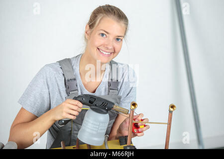 Signora utilizzando TORCIA SOFFIANTE Foto Stock