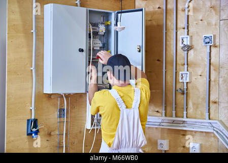 Elettricista consente il cablaggio in un quadro elettrico Foto Stock