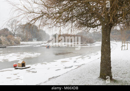 Ricoperto di ghiaccio di acqua in una barca sul lago in inverno nel Parco Mewsbrook, Littlehampton, West Sussex, in Inghilterra, Regno Unito. Foto Stock