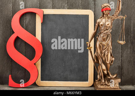 Justitia e paragrafo come diritto e legge concetto accanto a un vuoto di Blackboard Foto Stock