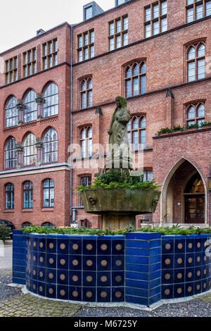 Berlino, Mitte, St Hedwigs ospedale, casa principale, neogotico in mattoni rossi ha elencato la costruzione esterna e facciata con sculture e Sant'Agata Fontana del CL Foto Stock