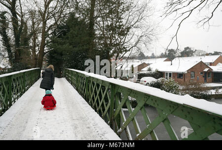 Un giovane ragazzo viene tirato lungo su una slitta su Basingstoke Canal vicino a Brookwood nel Surrey, come tempesta Emma, laminazione in dall'Atlantico, sembra pronta a soddisfare la Bestia da parte dell'est Russia gelida aria - causando ulteriori nevicate diffuse e temperature di amaro. Foto Stock