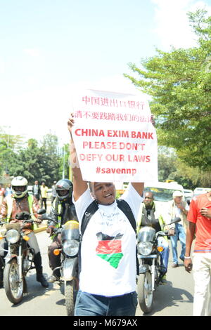 Nairobi, Nairobi, Kenia. 1 Mar, 2018. Un manifestante porta una targhetta sulla Uhuru Highway Nairobi durante una manifestazione contro la costruzione della seconda fase della ferrovia attraverso il Parco Nazionale di Nairobi. Conservazionista sono contro la costruzione citando il negativo impatto che esso avrà sul parco. Credito: DSC 1590.jpg/SOPA Immagini/ZUMA filo/Alamy Live News Foto Stock