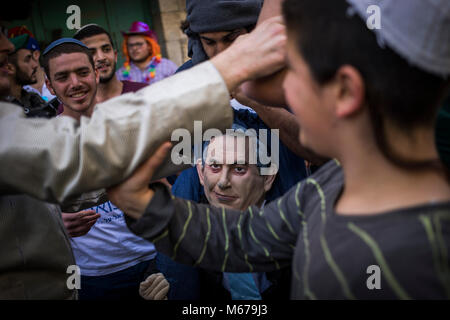 Dpatop - Costume i coloni israeliani tenere una maschera del Primo ministro israeliano Netanyahu che prendono parte alla parata segna la festa ebraica di Purim in divisa in Cisgiordania città di Hebron, 01 marzo 2018. La carnevalesca Purim holiday è celebrata con sfilate in costume e parti per commemorare la liberazione del popolo ebraico dalla un complotto per sterminarli nell'antico impero persiano 2.500 anni fa, come registrato nel libro biblico di Ester. Foto: Ilia Yefimovich/dpa Foto Stock