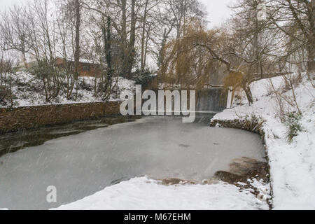 Sidmouth, Devon, 1 Marzo 18 neve e ghiaccio stabilirsi presso la diga sul fiume Sid a Sidmouth inquanto Bestia da Est incontra tempesta Emma oltre a sud ovest dell'Inghilterra. Devon e Cornwall aspettano di diversi centimetri di neve nelle prossime ore. La neve è una grande rareity sulla costa del Devon - Sidmouth ha avuto nessuno poiché l'inverno 2010/11. Foto centrali/Alamy Live News Foto Stock