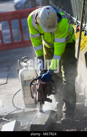 Workman con wet sega circolare per il taglio di calcestruzzo Foto Stock