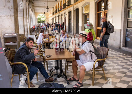 La mezza età uomo a suonare la chitarra e cantare in Pavement Cafe, Plaça de la Independencia, Girona, Catalogna, Spagna Foto Stock