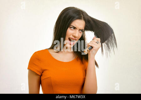 Donna con capelli arruffati bloccato nel pettine Foto Stock