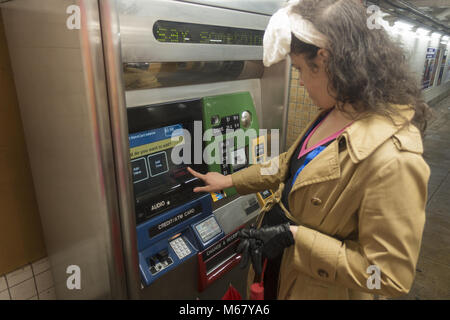 Donna ricariche il suo Metro Card presso una stazione della metropolitana di Brooklyn, New York. Foto Stock