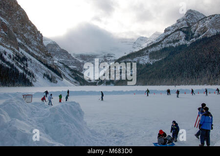 Persone pattinaggio sul ghiaccio sulla superficie ghiacciata al Lago Louise nel Parco Nazionale di Banff, Alberta, Canada, gennaio 22nd, 2011 Foto Stock