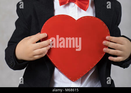 Ragazzo di 4 anni mantiene il cuore rosso scatola. Primo piano Foto Stock