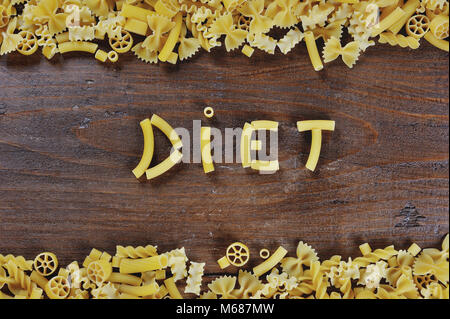 La pasta italiana La cucina in legno marrone di sfondo - La dieta parola scritta con pasta Foto Stock