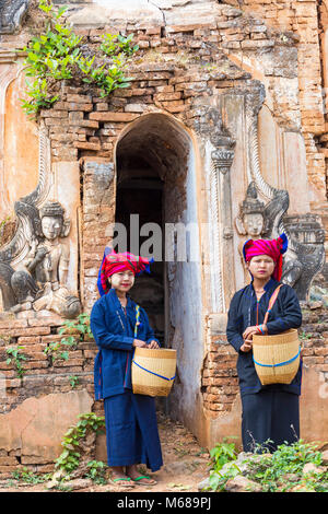 Giovani Pa o Signore che trasportano i cestini & thanaka sulla faccia a Shwe Indein Pagoda Complex, Shan state, Inle Lake, Myanmar (Birmania), Asia nel mese di febbraio Foto Stock