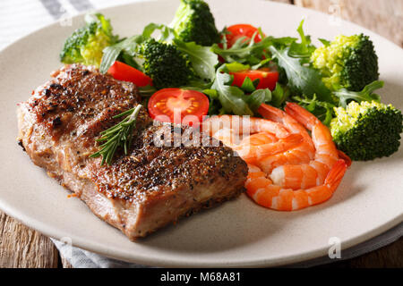 Surf and Turf. Bistecca di manzo con royal e gamberetti e verdure fresche di close-up su una piastra su un tavolo. Posizione orizzontale Foto Stock