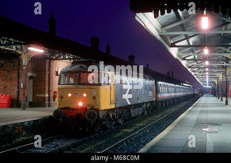 Una classe 47 locomotiva diesel numero 47526 lavora una rete sud-est "Network Express' Inghilterra Occidentale service mette in pausa a Salisbury per la fermata prenotata come tramonto. 14 febbraio 1993. Foto Stock