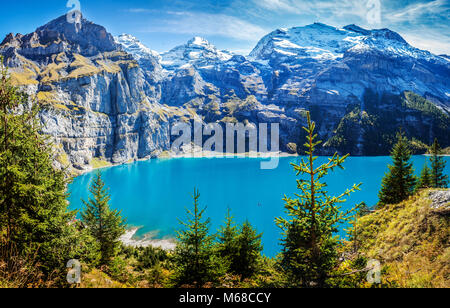 Vista panoramica del famoso lago di montagna oeschinensee in Svizzera kandersteg tarda estate nelle alpi con neve coperto vette Foto Stock