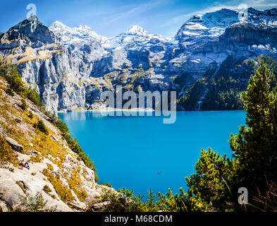 Vista panoramica del famoso lago di montagna oeschinensee in Svizzera kandersteg tarda estate nelle alpi con neve coperto vette Foto Stock