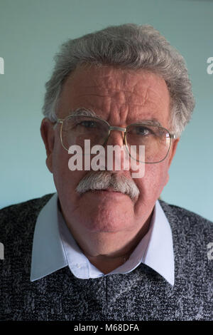 Colpo alla testa di un amichevole avvicinabile bianco pensionato anziano uomo con i baffi e occhiali di protezione Foto Stock