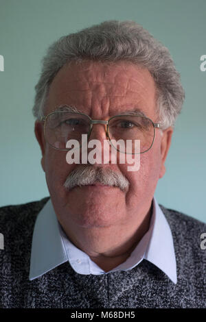 Colpo alla testa di un amichevole avvicinabile bianco pensionato anziano uomo con i baffi e occhiali di protezione Foto Stock