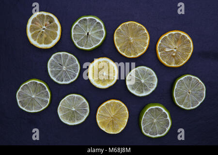 Limone fettine di lime del cibo su sfondo scuro Foto Stock