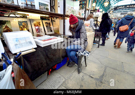 Londra, Inghilterra, Regno Unito. Stallholder nel mercato di Covent Garden, sul suo telefono cellulare Foto Stock