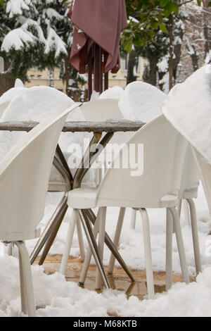 I tavoli e le sedie di un cafe bar, coperte di neve Foto Stock