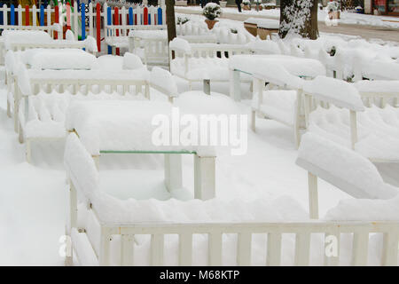 I tavoli e le sedie di un cafe bar, coperte di neve Foto Stock