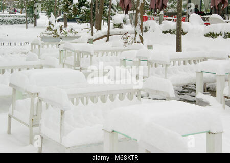 I tavoli e le sedie di un cafe bar, coperte di neve Foto Stock