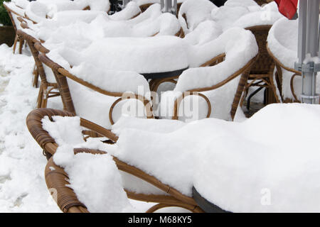 I tavoli e le sedie di un cafe bar, coperte di neve Foto Stock