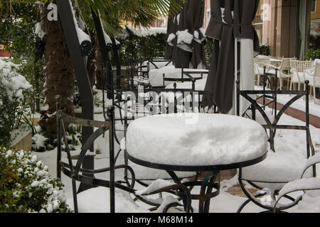 I tavoli e le sedie di un cafe bar, coperte di neve Foto Stock