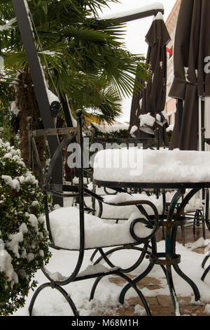 I tavoli e le sedie di un cafe bar, coperte di neve Foto Stock