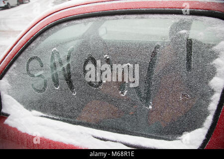 La neve è scritto su una finestra di auto come la gente lotta per andare sulla loro vita quotidiana in caso di gelo, soprannominato "La Bestia da est' a causa del sub zero temperatura freddo vento proveniente dalla Siberia, scende sul Kings Heath High Street il 1 marzo 2018 a Birmingham, Regno Unito. Foto Stock