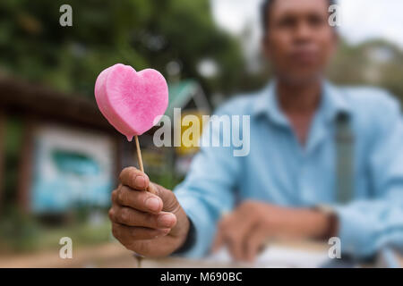 Pyin Oo Lwin, Myanmar - Ottobre 3, 2016: Non identificato uomo birmano rosa la vendita di gelati in forma di cuore per le strade di Pyin Oo Lwin, Birmania Foto Stock