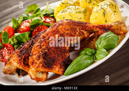 Arrostire le cosce di pollo con patate lesse e insalata di verdure Foto Stock