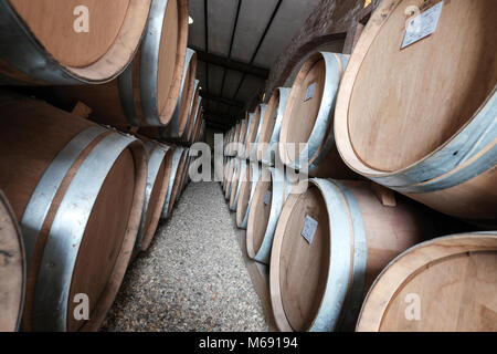 Botti da vino impilati nella vecchia cantina Foto Stock