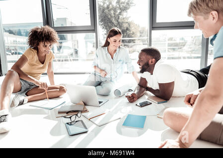 Felice persone positive per discutere le loro idee Foto Stock