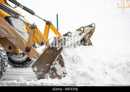 Rimozione della neve dal trattore in città. Vista ravvicinata sulla siviera con la neve Foto Stock