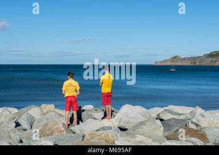 Bagnini RNLI patrol Runswick Bay è uno della costa dello Yorkshire più belle destinazioni. La spiaggia di sabbia, che una volta fornito di ancoraggio per brightl Foto Stock