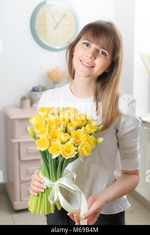 Narcissus bellissimi fiori in mano womans. bouquet di delicato colore giallo. Il lavoro del fioraio presso un negozio di fiori. Foto Stock