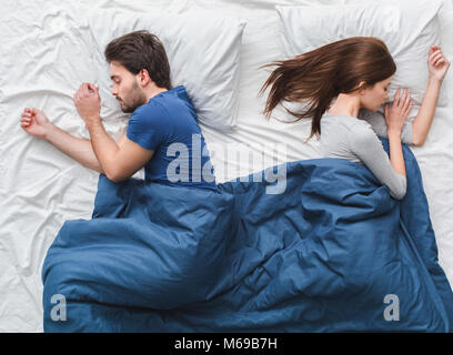 Coppia giovane a letto vista dall'alto il concetto di mattina dormire su lati diversi Foto Stock