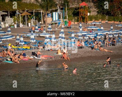 I turisti in mare e sulla spiaggia, Positano, Costiera Amalfitana, Italia. Foto Stock