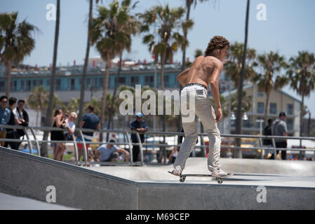 Giovane guidatore di skateboard al skatepark sulla famosa Spiaggia di Venice Boardwalk uno dei più popolari attrazioni della California. Foto Stock