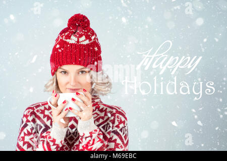 Bella donna in Caldo berretto lavorato a maglia è di bere il caffè. Natale e Anno Nuovo Foto Stock