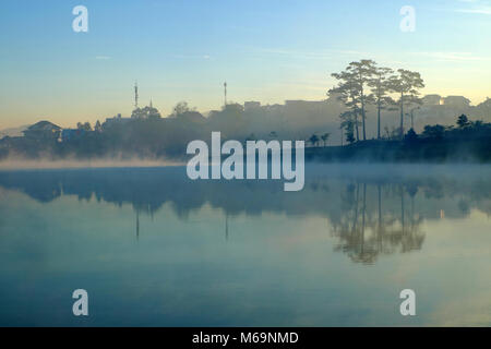 Splendidi paesaggi di Da Lat Città al mattino con il lago nella nebbia, pino riflettere sull'acqua, scenario in ciano, destinazione romantica per il Vietnam travel Foto Stock