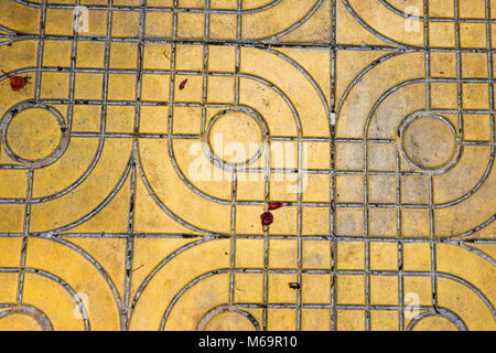 Giallo modellato piastrelle sulla strada, vista dall'alto. Mattoni di cemento, pietra squadrata piano terra texture di sfondo. Pavimentazione in calcestruzzo bramma in lastricato. Il marciapiede marciapiede pattern con wet footp Foto Stock