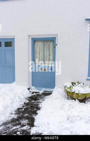 Neve cancellata dalla porta anteriore di un cottage del villaggio di Wrington, North Somerset, Inghilterra. Foto Stock