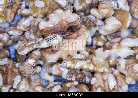 Close up di pelo di inglese di noci tagliate a metà con etichetta nutrizionale. Foto Stock