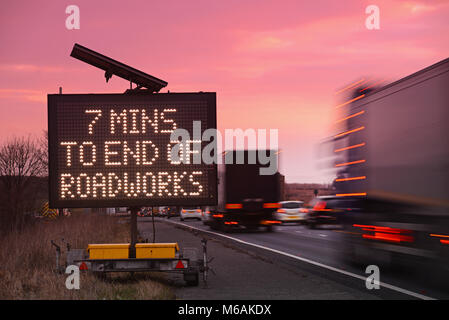 Traffico di transito stradale digitale all'alba sulla A64 per gli automobilisti che mostra 7 minuti di tempo di guida al fine di lavori stradali Leeds REGNO UNITO Foto Stock